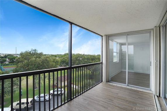 View from a balcony showing greenery and distant landscape.