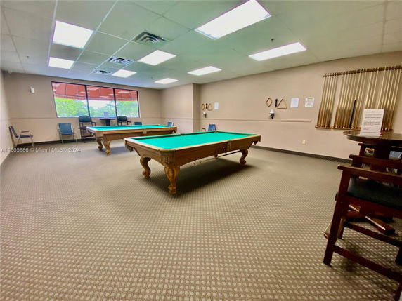 Billiards room with two pool tables and seating area.