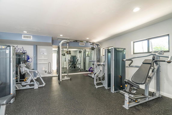 Indoor gym area with various exercise equipment and machines.