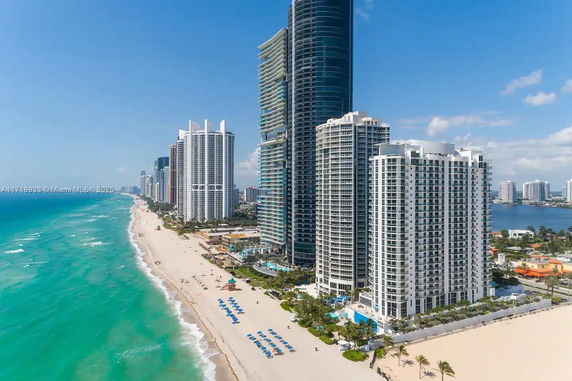 Aerial view of a beachfront with multiple high-rise buildings along the coastline.