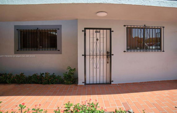 Front view of a house with a secure door and barred windows.