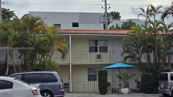 Front view of a two-story apartment building with a red tile roof.