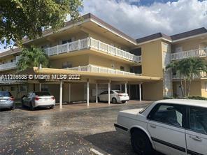 Front view of a multi-story building with balconies and covered parking.
