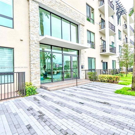 Front view of a modern multi-story building with large glass entrance.