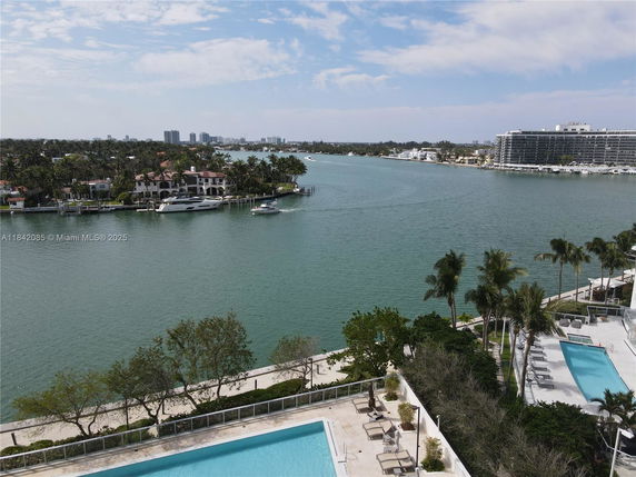 Wide angle view of waterfront area with swimming pools and a canal.