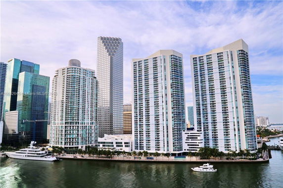 View of a group of modern high-rise buildings near a waterway.