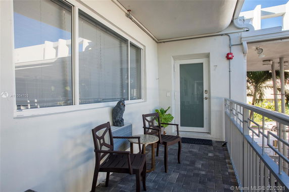 Outdoor seating area next to a window and door on a building's exterior.