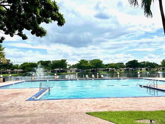 Outdoor swimming pool with surrounding landscape and water view.