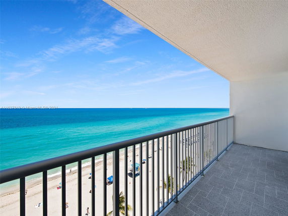View from a balcony overlooking the beach and ocean.