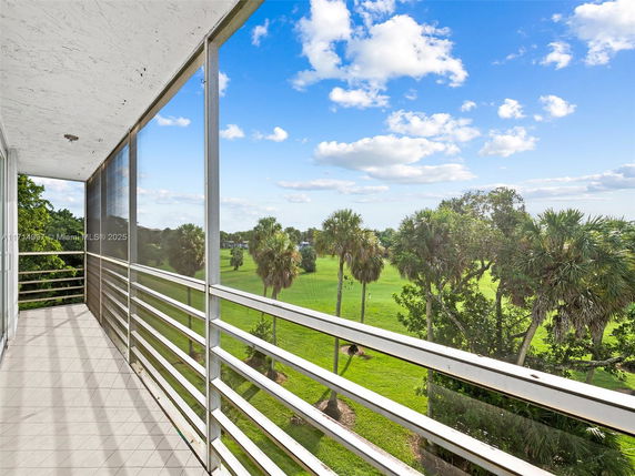 View of surrounding greenery and trees from a building balcony.