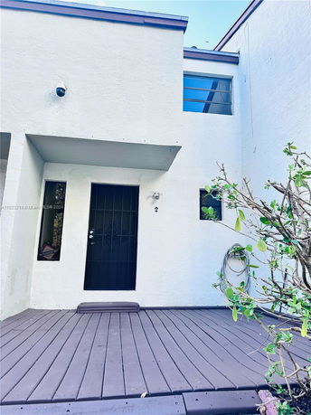 Front view of a two-story building with a door, window, and small porch area.