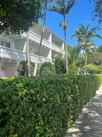 Front view of a three-story building with balconies and decorative railings.