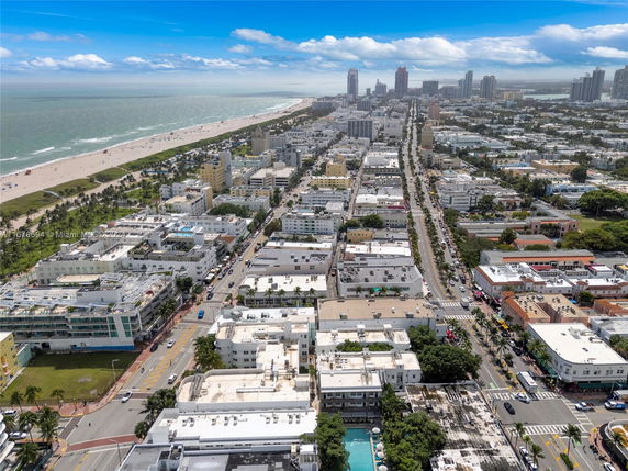 Aerial view of a coastal city with buildings, streets, and a beach.