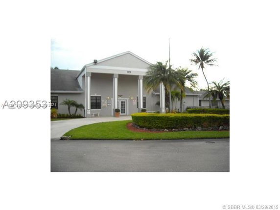Front view of a building with tall pillars and a gable roof.