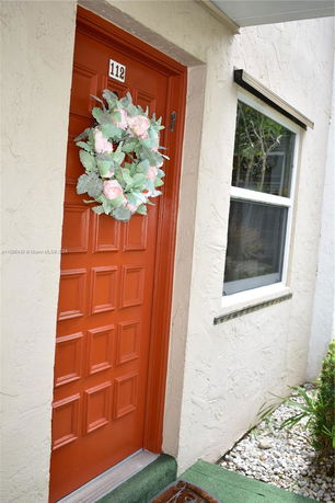 Front view of a house with a red door and decorative wreath.