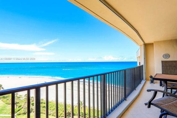 Panoramic view of the beach and ocean from a balcony.