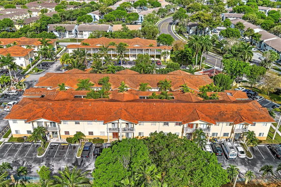 Aerial view of a residential complex with red-tiled roofs and surrounding greenery.