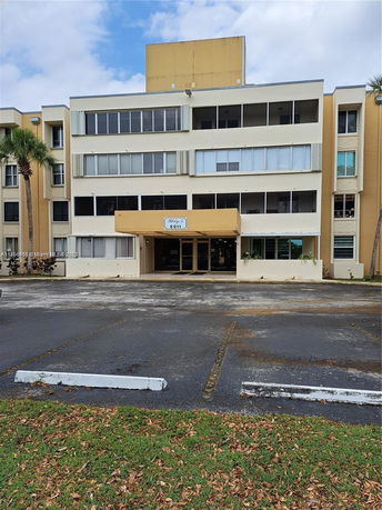 Front view of a multi-story building with a flat roof and multiple windows.