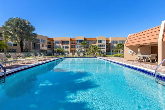 Swimming pool area in front of a multi-story residential building.