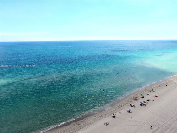 Panoramic view of a sandy beach and turquoise ocean.