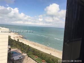 View of a beach and ocean from a building window.