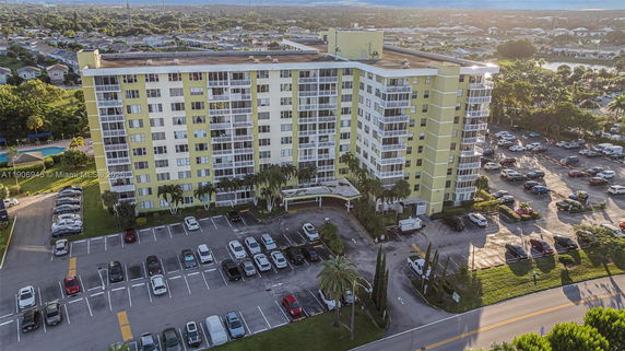 Front view of a multi-story residential building with a parking area.