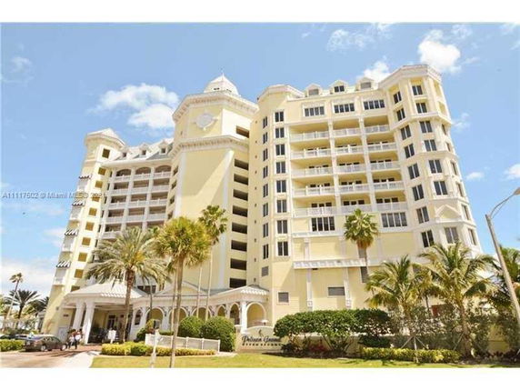Front view of a multi-story residential building with balconies and architectural details.