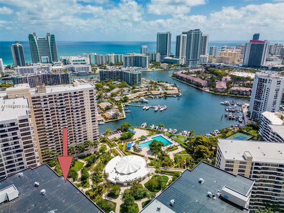 Panoramic view of high-rise buildings near a marina with a swimming pool and cityscape in the background.