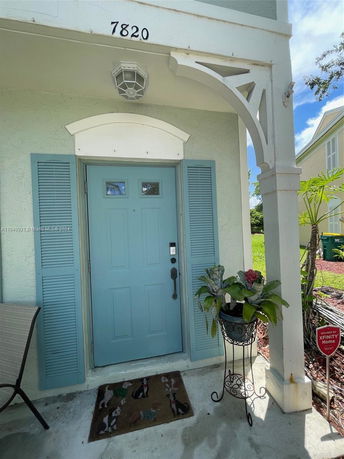 Front view of a house with a blue door and decorative molding.