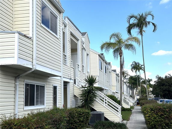 Front view of multi-story townhouses with external staircases and balconies.