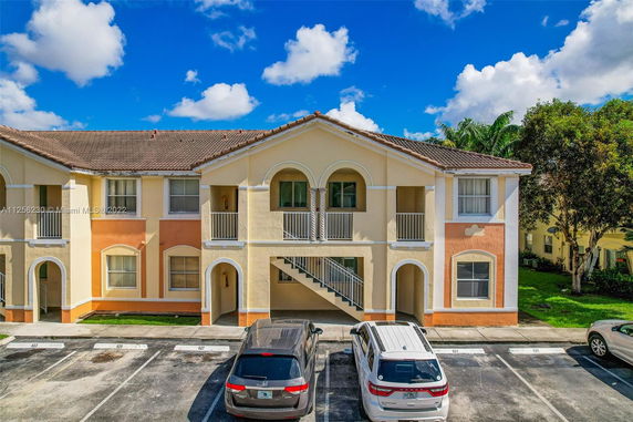 Front view of a two-story residential building with arches and balconies.