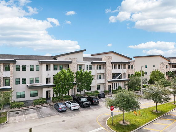 Front view of a multi-story building with parking area.