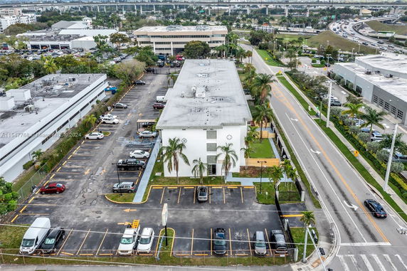 Aerial view of a large parking lot adjacent to a multi-story building.