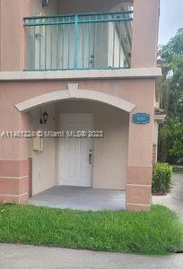 Front view of a house entrance with an arched doorway and a small balcony above.