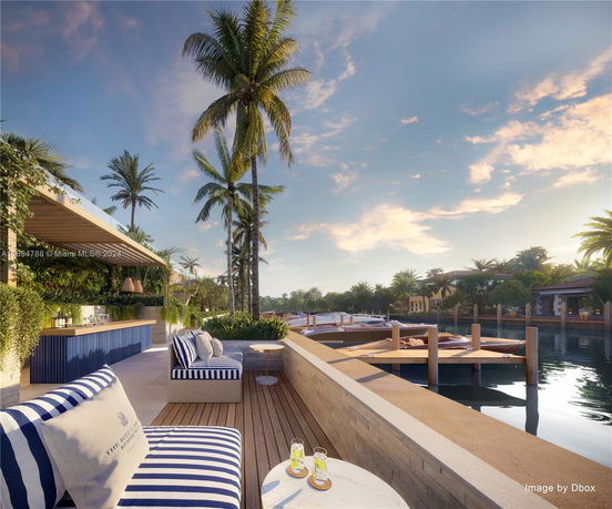 Outdoor seating area with a view of a waterfront and palm trees.