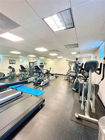 Interior view of a gym with various exercise equipment like treadmills and ellipticals.