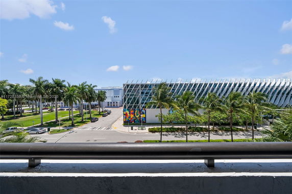 View of a modern building with a unique architectural design and palm trees.