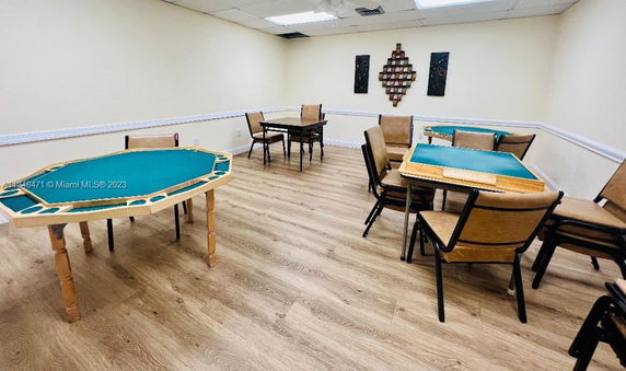Room with multiple card tables and chairs in a clubhouse setting.