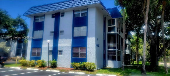Front view of a multi-story building with blue accents and a gabled roof.