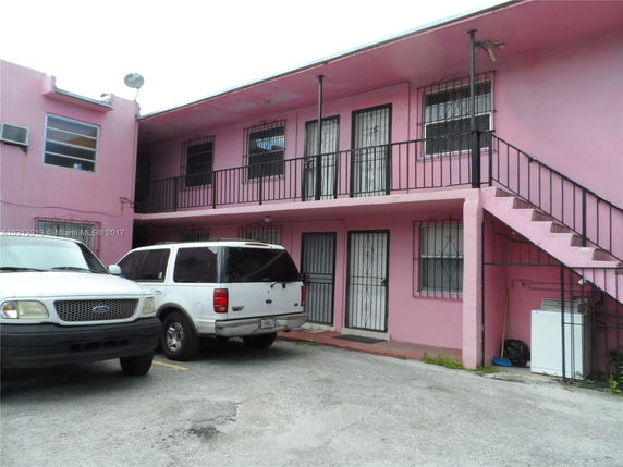 Front view of a two-story building with a parking area.