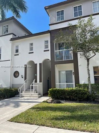 Front view of a multi-story townhouse with a small balcony.
