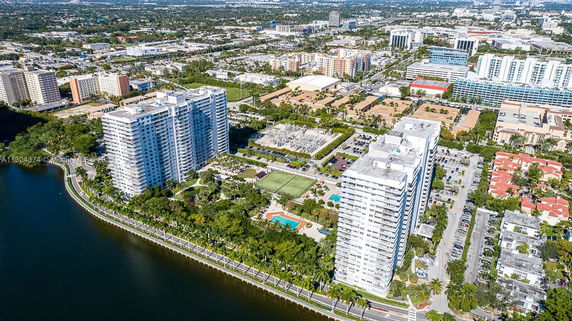Aerial view of tall residential buildings near waterfront in an urban setting.
