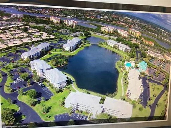 Aerial view of a residential area with multiple buildings surrounding a central pond.