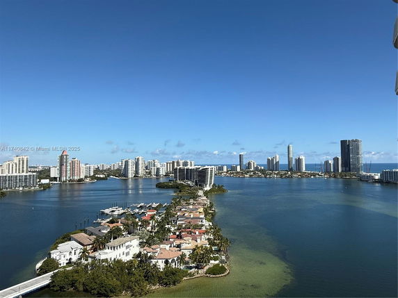 Panoramic view of a waterfront cityscape with skyscrapers and residential buildings.
