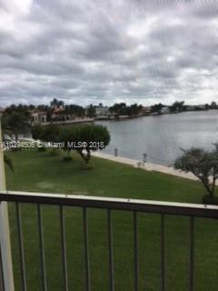 Panoramic view of a lake and surrounding residential area from a balcony.