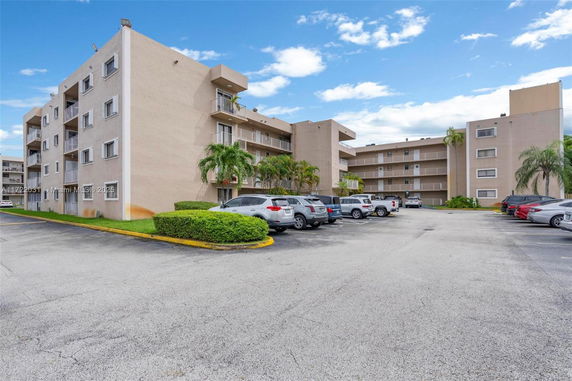 Front view of a multi-story apartment building with balconies.