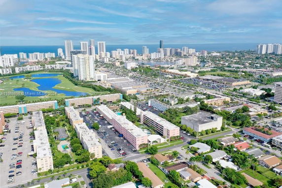 Panoramic view of a cityscape with multiple buildings and a water body in the distance.
