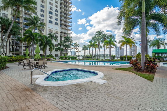 Outdoor swimming pool area with surrounding high-rise buildings.