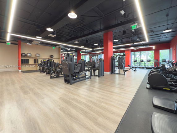Interior view of a gym with exercise machines and large windows.