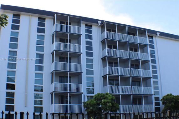 Front view of a multi-story apartment building with balconies.
